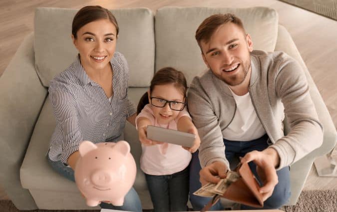 Boldog család pénzt tart a kezében, a pénzügyi biztonság és adómentes megtakarítás jelképeként