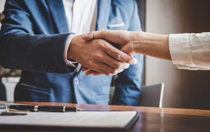 Kézfogás, amely a kegyeleti biztosítás gyors pénzügyi segítségét szimbolizálja
