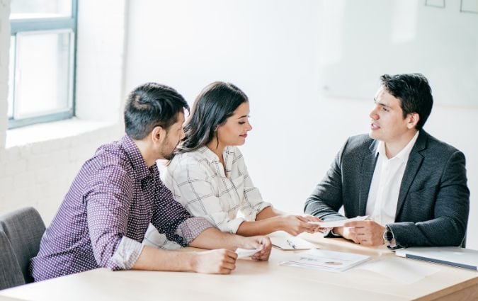 Tanácsadóval beszélgető házaspár az első pénzügyi konzultáción